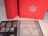 an open red book with stamps on it sitting on top of a table