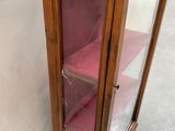 a display cabinet with a glass door and shelves