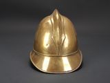 brass fire helmet on a black background with a gray background