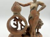 figurine représentant une femme tenant un sac d'argent devant une horloge
