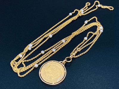 un gros plan d'un collier avec une pièce suspendue à une chaîne