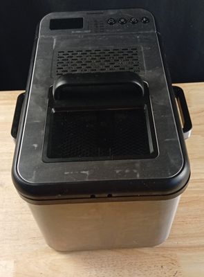 une photo représentant un récipient en plastique noir posé sur une table en bois