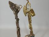 statue of a woman holding a fan next to a statue of a man holding a fan