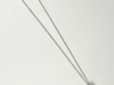 silver necklace with black and white pearls on a white background