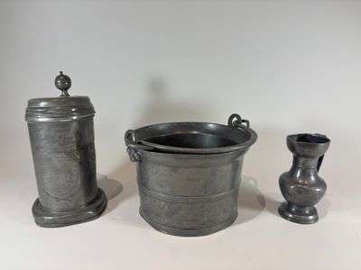 a silver container and two vases sitting on a table
