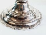 a silver candle holder on a white table
