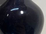 a black vase that is sitting on a table