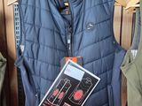 un gilet bleu sur un cintre, à côté d'un pantalon vert