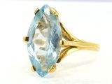 an image of a gold ring with a blue topazt stone
