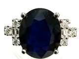 a close up of a blue sapphire and diamond ring on a white background