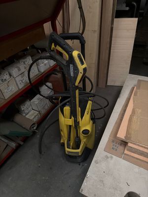 un nettoyeur haute pression jaune et noir rangé dans un garage