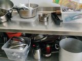 many pots and pans sitting on a metal table