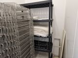 une pièce avec une cage métallique et une étagère sur laquelle sont posées des serviettes