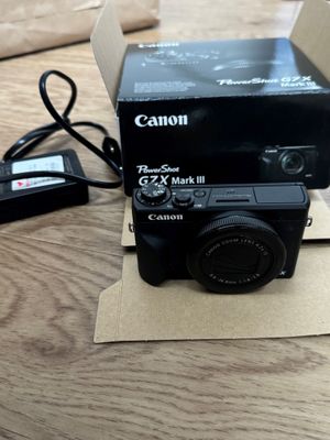 a black camera sitting on top of a cardboard box on a table