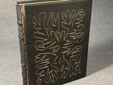 a black book with gold writing on it sitting on a gray surface