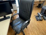 a desk with a computer and a chair in a room