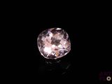 a close up of a pink diamond on a black surface