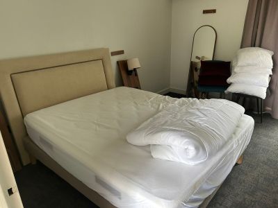 un lit avec des draps et des oreillers blancs dans une chambre