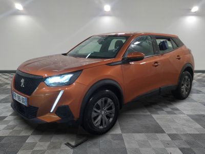Le SUV orange est garé sur un sol en carrelage à damier.