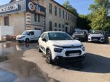 a small white car parked in front of a building