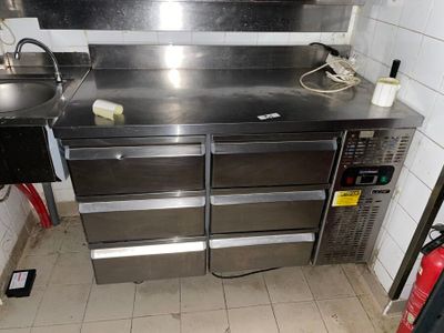 a stainless steel workbench in a kitchen with a sink