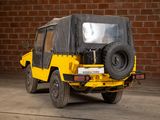 a yellow and black jeep parked in front of a brick wall