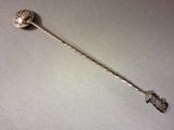 a silver spoon with a ball on it on a table