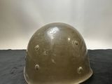 an army helmet on a black surface with a light shining in the background
