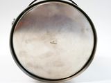 a silver plate with a handle on a white surface