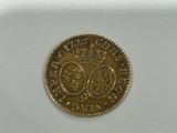 a close up of a gold coin on a white surface