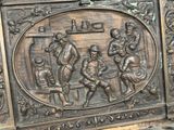a metal plaque with a picture of a group of people on it