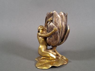 a gold statue of a man holding a large shell