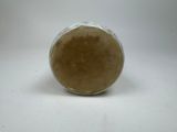 a glass jar with a brown substance inside of it