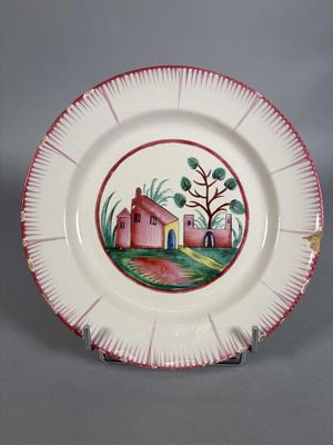 une assiette sur laquelle est représentée une maison