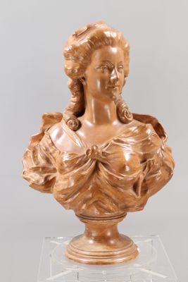 carved bust of a woman in a dress on a clear base