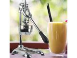 a glass of orange juice next to an orange juice machine
