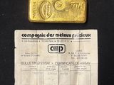 a gold bar and a certificate on a black table