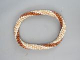 un gros plan d'un bracelet en perles posé sur une surface blanche