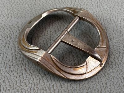 a close up of a metal buckle on a leather surface