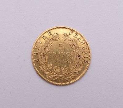 gros plan d'une pièce d'or sur une surface blanche