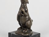 sculpture représentant un lapin posée sur un socle en marbre