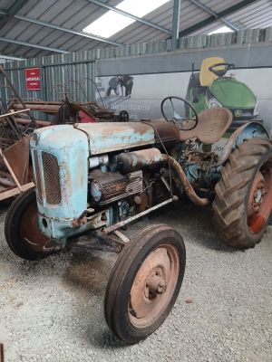 un vieux tracteur qui est rangé dans une grange