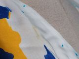 a close up of a woman ' s neck with a yellow and blue flower on it