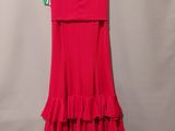 a red dress hanging on a hanger against a wall
