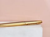 a gold fountain pen sitting on top of a marble block