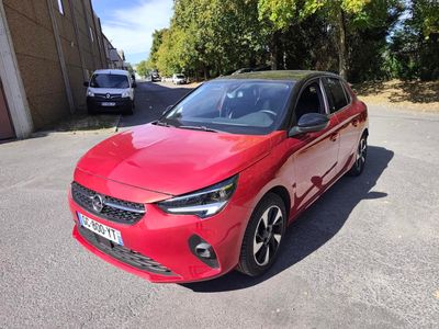 the red car is parked in the parking lot next to a building