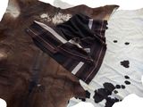 a brown and white cowhide rug with a black and white blanket