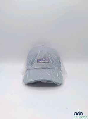 le chapeau est emballé dans du plastique et posé sur une surface blanche