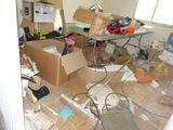 une pièce où il y a beaucoup de cartons et d'autres objets par terre