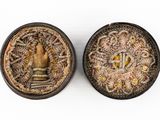 pair of two small tins with a hand inside of them on a white surface